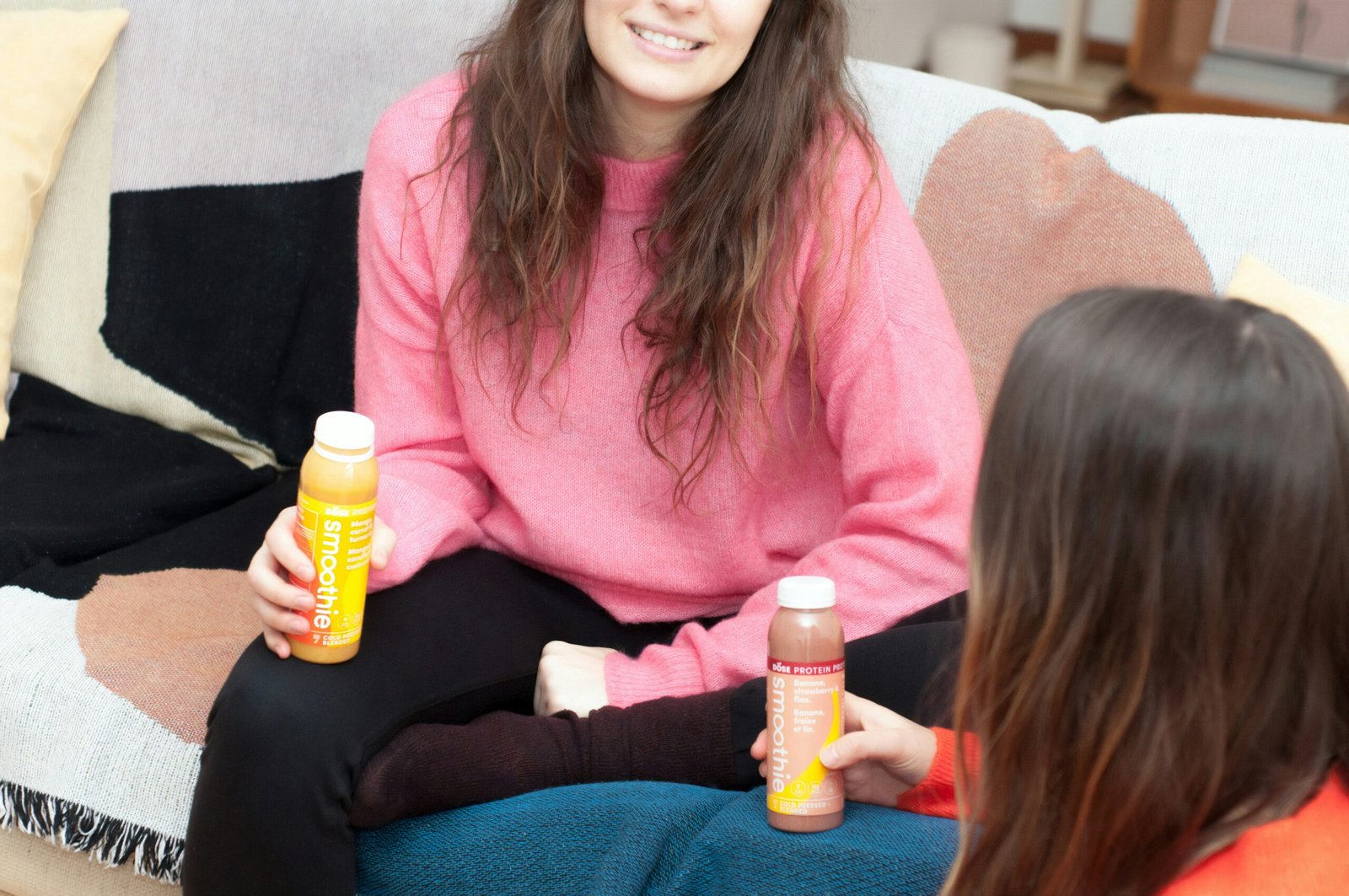 two women holding smoothie bottles